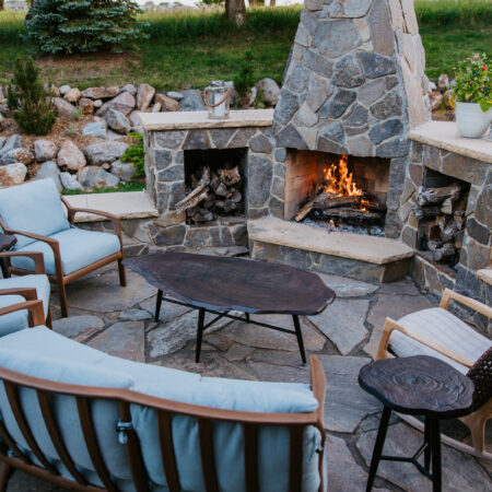 custom outdoor furniture by stone masonry fireplace