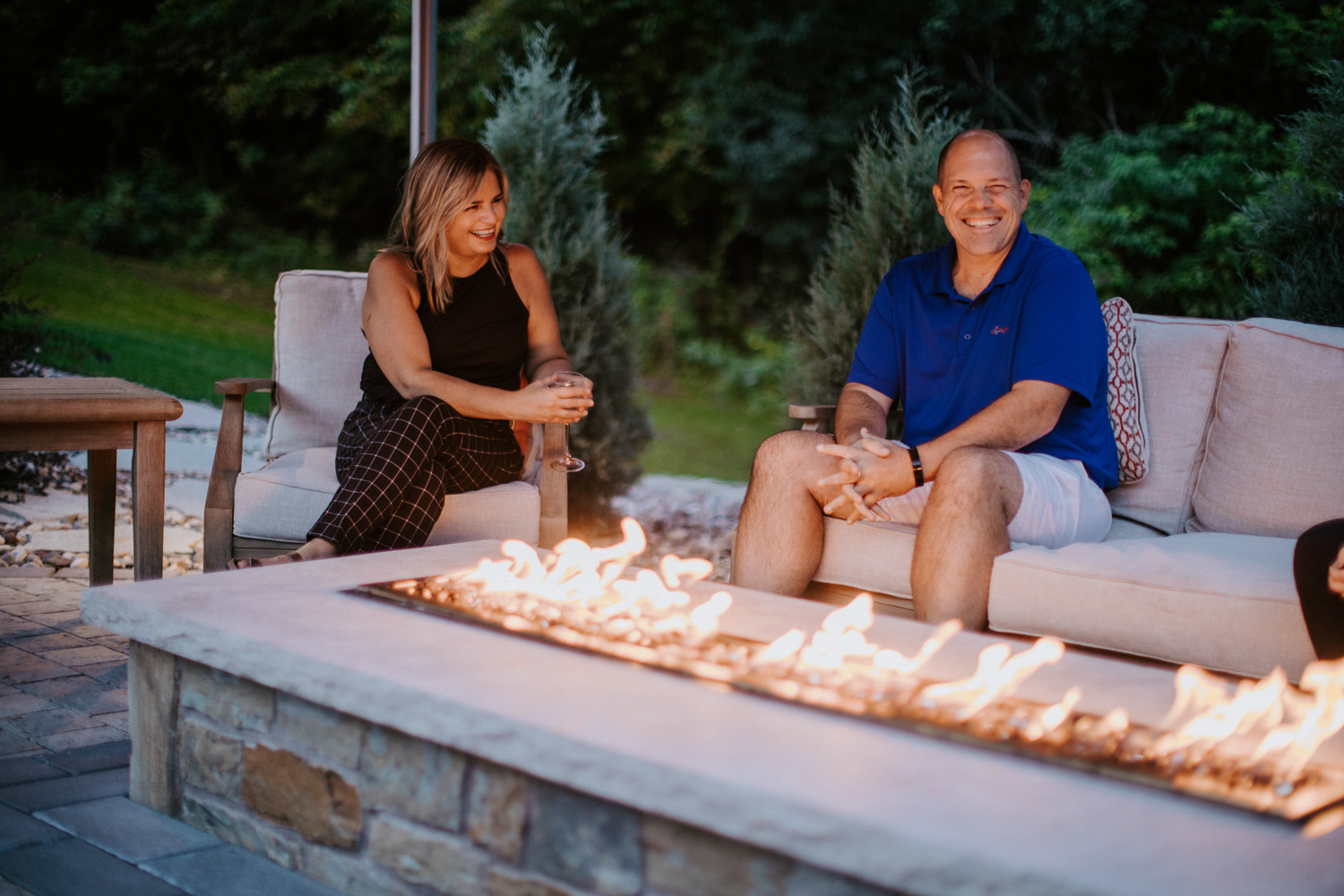 couple laughing by a fire pit