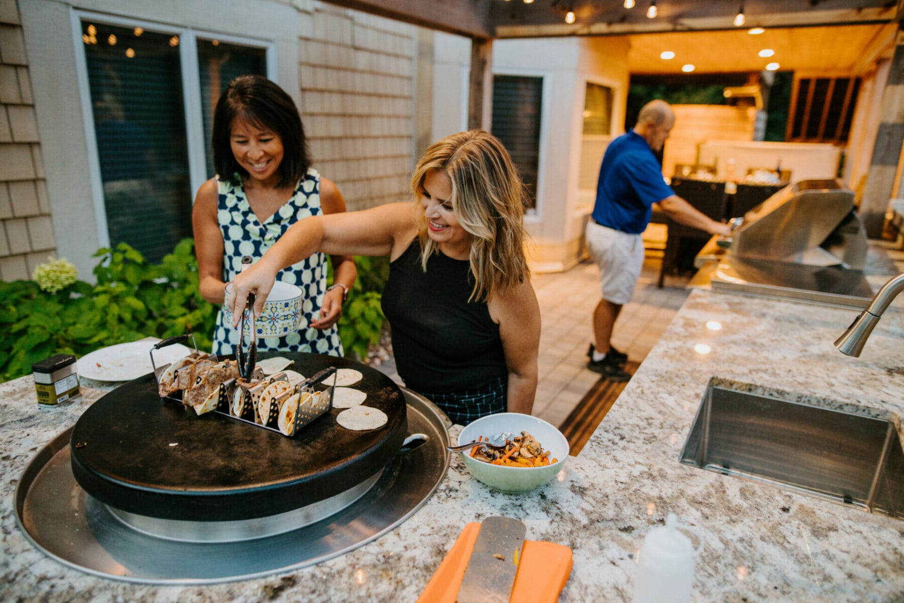 homeowners cooking tacos on their evo flat top grille