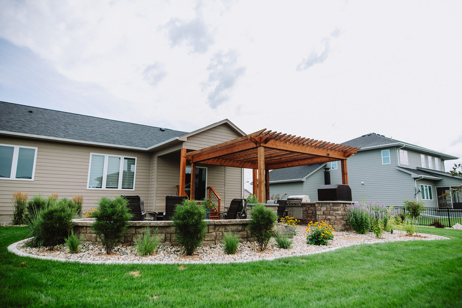 backyard landscaping with outdoor kitchen and pergola