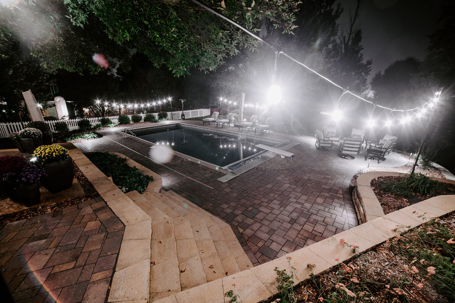 lit backyard pool at night