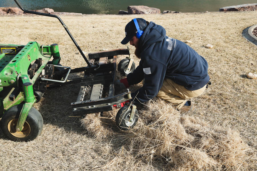 Maintenance Tech pulling out thatch from a Spring Power Rake