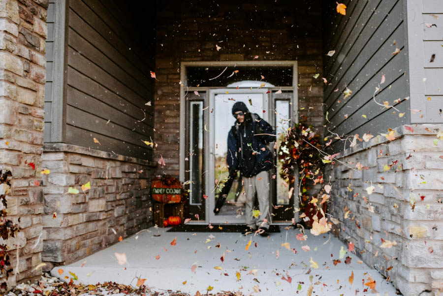 Lawn care employees removing leaves from front porch