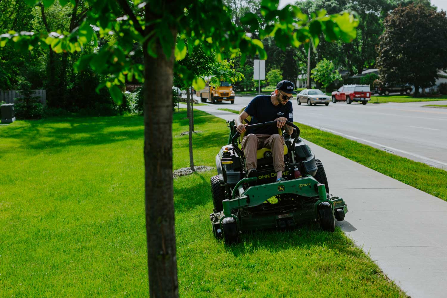 Weller Brothers employee mowing a lawn in Rochester, MN on a zero-turn mower