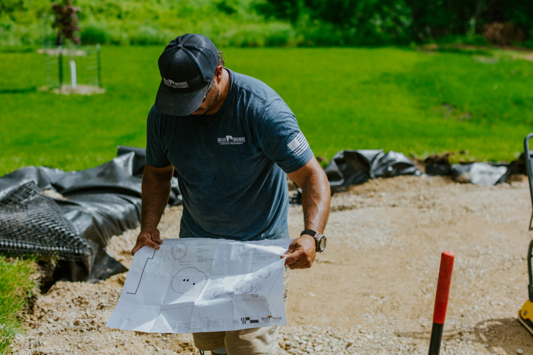 Wes Busch of Weller Brothers Landscaping reads a landscape plan on the job site