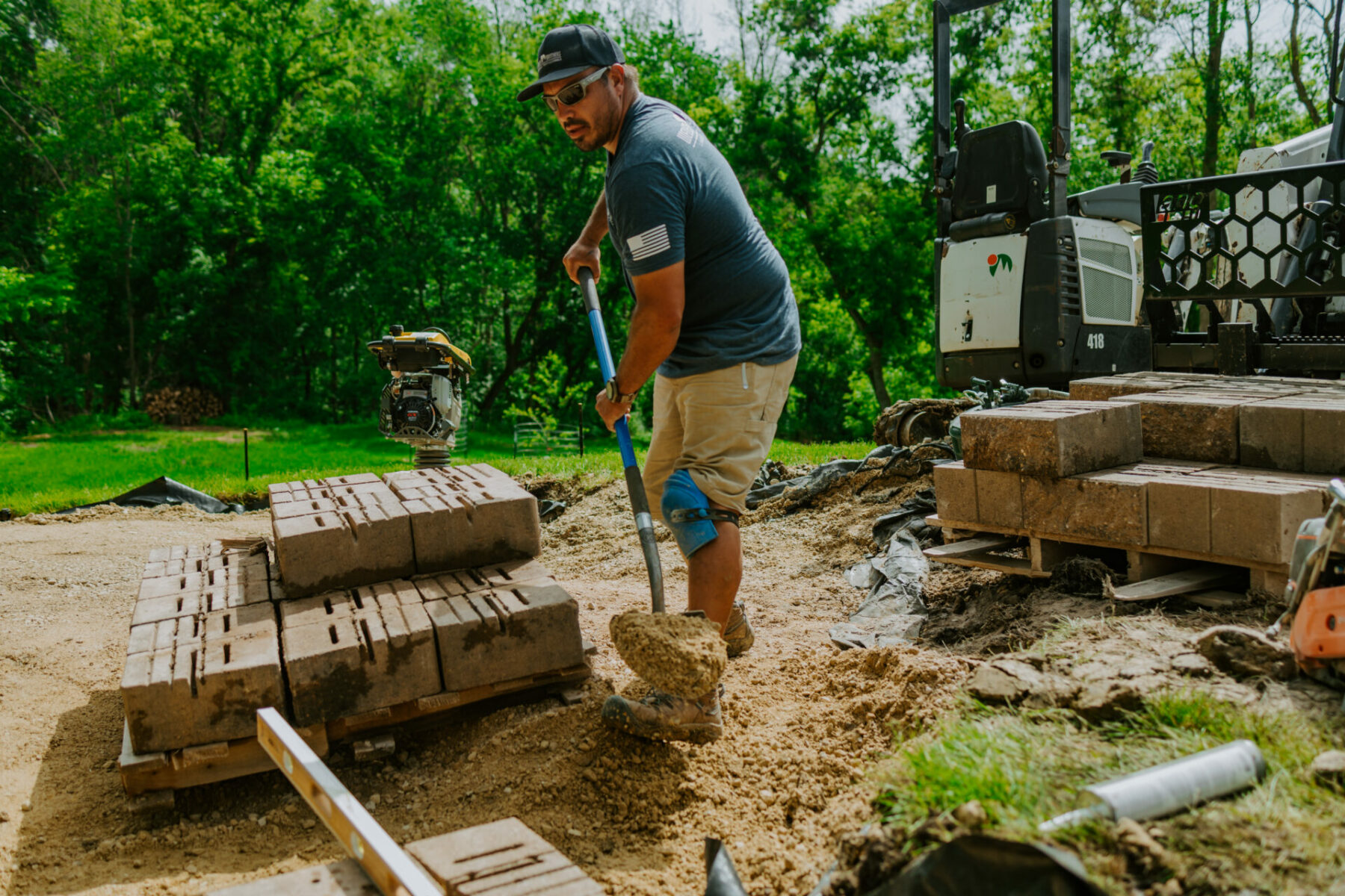 Wes Busch of Weller Brothers Landscaping shoveling sand