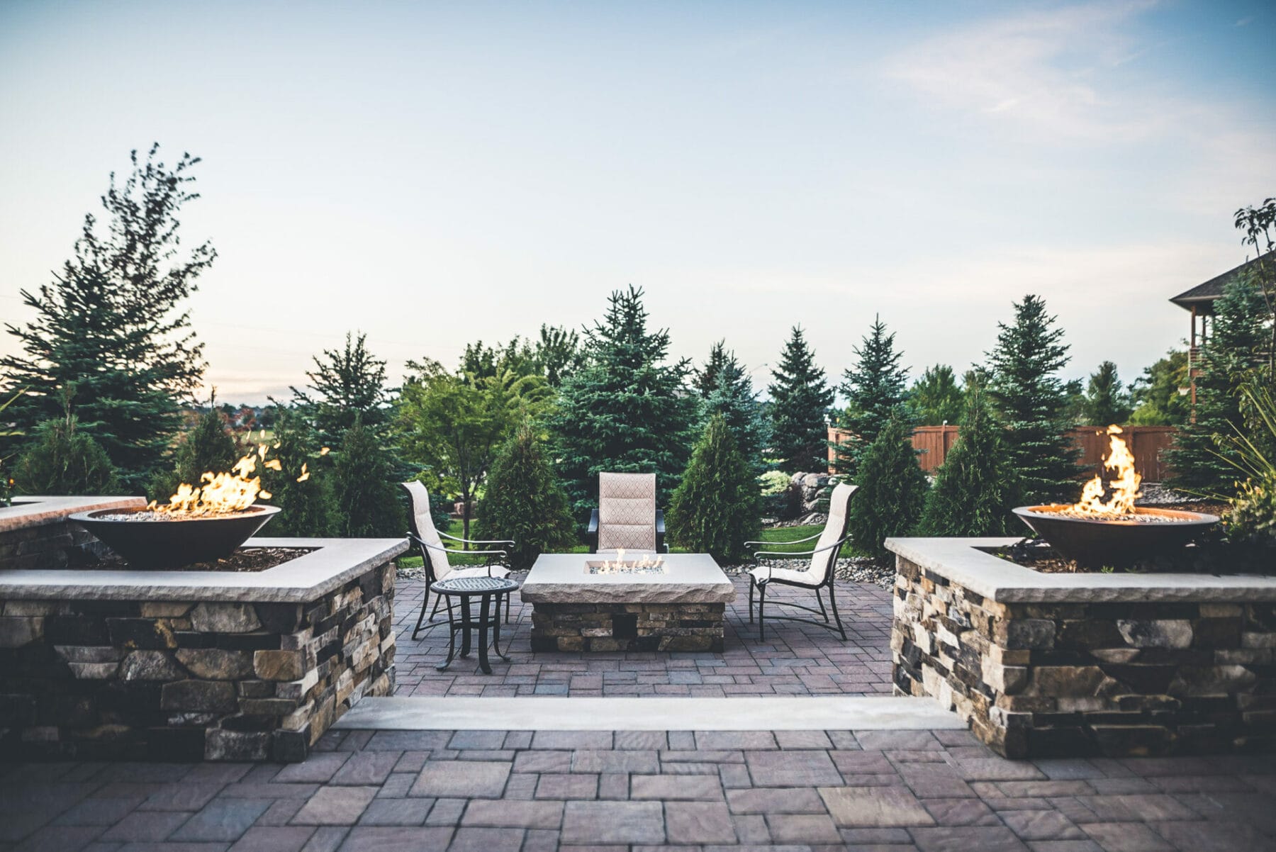 residential patio and fire pit with conifer trees