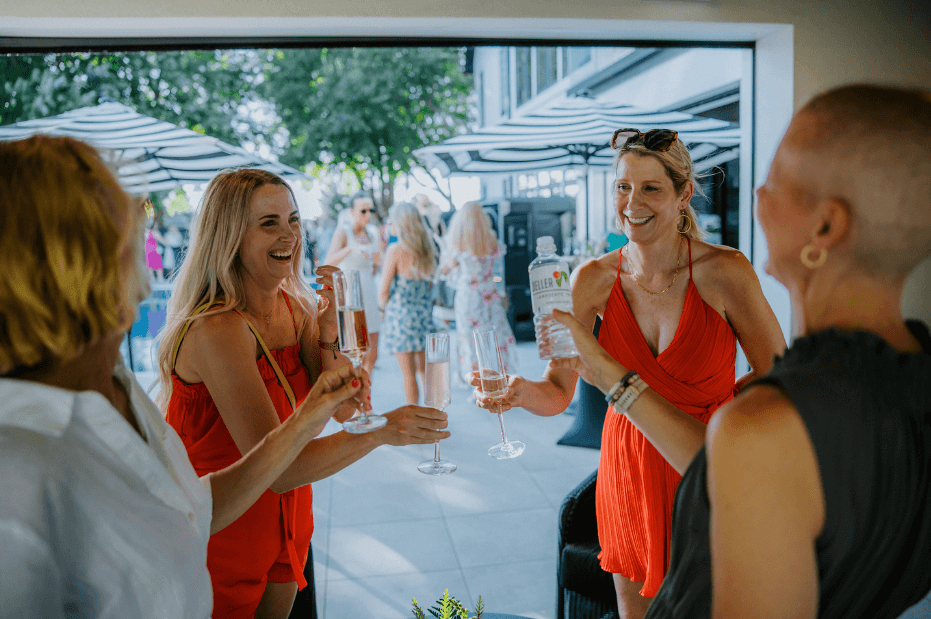 four women laughing at a backyard party