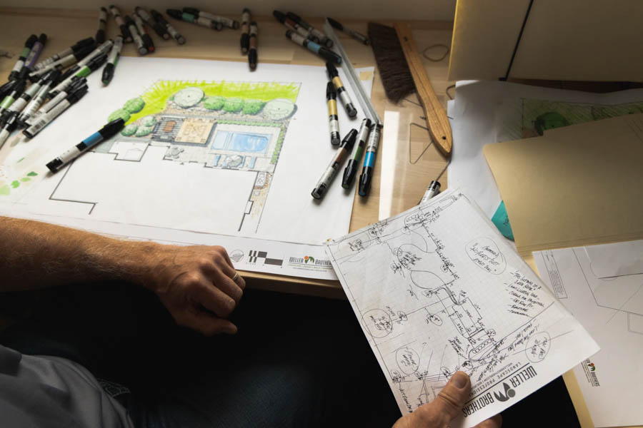 Weller Brothers landscape designer holding hand-drawn custom design