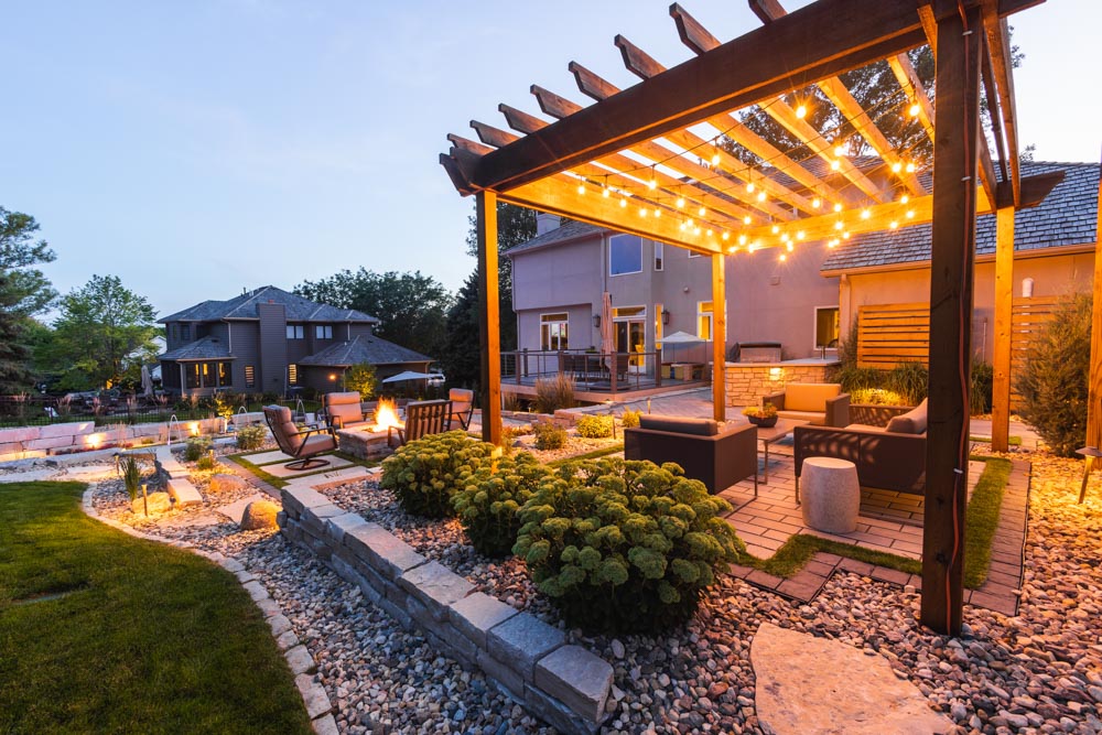 Backyard pergola with landscape lighting at night