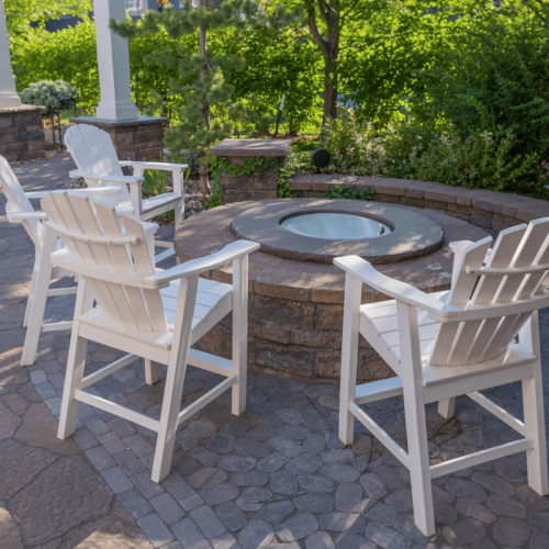 custom backyard fire pit with white chairs