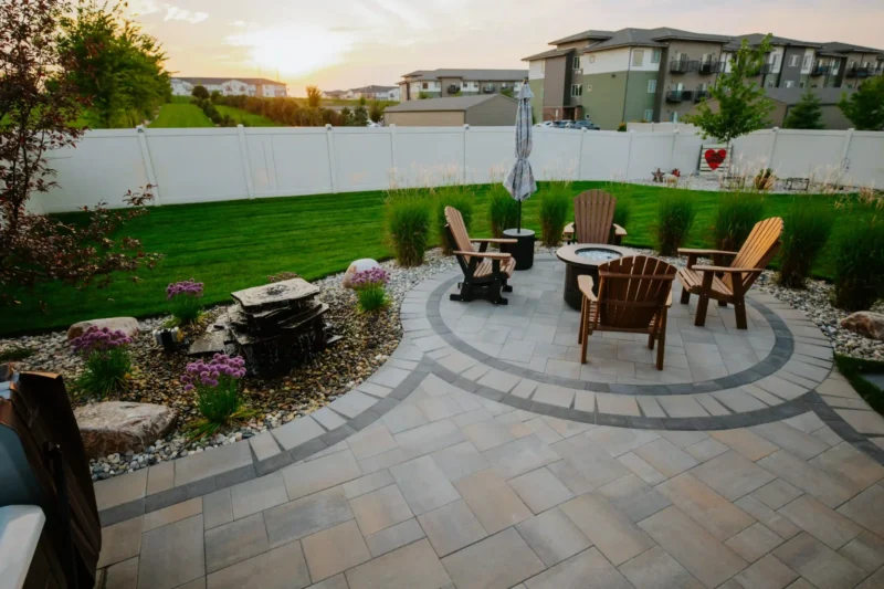 backyard designed patio with pavers and tile, firepit, and plantings