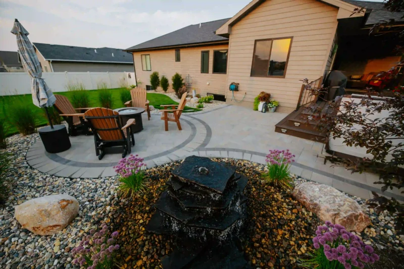 backyard designed patio with pavers and tile, fire pit, and plantings