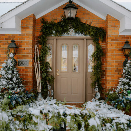 front porch of a home with evergreens and garland