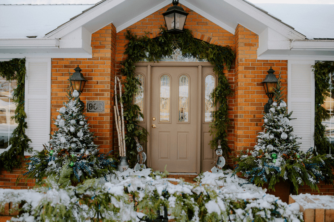 front porch of a home with evergreens and garland